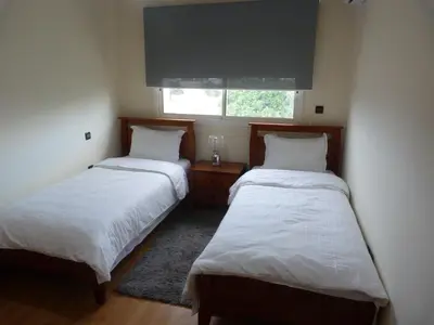 two beds in a small room with a window at Résidence les Ambassadeurs in Rabat