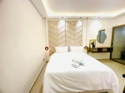 a bedroom with a large white bed and a mirror at Calm&cosy appart very well located in Casablanca