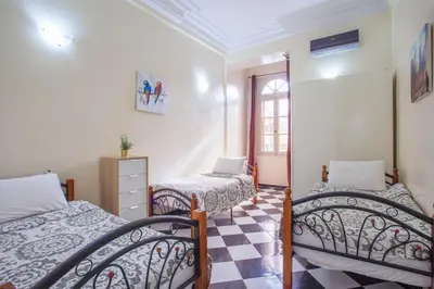 a bedroom with two beds and a checkered floor at appartement haussmannien centre ville Casablanca in Casablanca