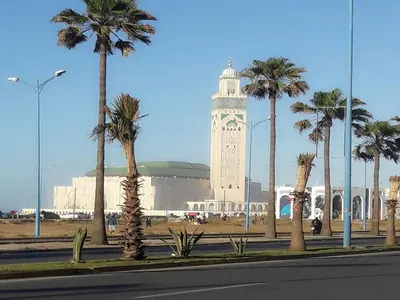a tall clock tower with palm trees in front of a building at Horizon Garden Home in Casablanca