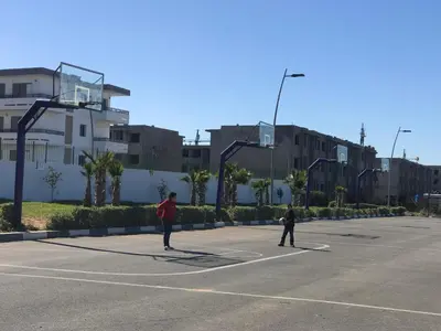 two people are playing in a parking lot at Marbella Beach location pour famille 2 chambres in Mansouria