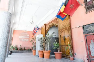 an entrance to a building with flags and potted plants at Hotel Moroccan House Casablanca in Casablanca