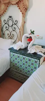 a bedroom with two swans on top of a bed at Hotel Moroccan House Casablanca in Casablanca