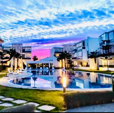 a large swimming pool in front of some buildings at Appartement Blanca Beach in Sidi Rahal