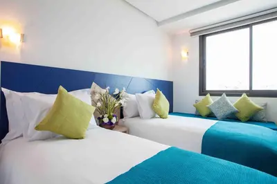 two beds in a room with blue and white at Relax Hotel Casa Voyageurs in Casablanca