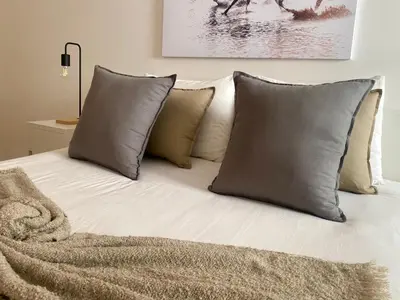 a bed with a bunch of pillows on it at Appartement les pieds dans l'eau WELCOME STAY in Mohammedia