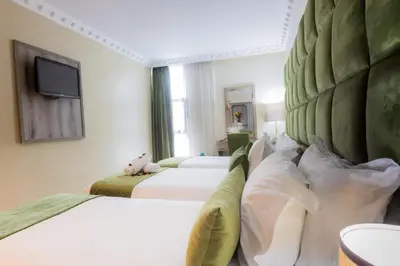 a hotel room with two beds and a flat screen tv at Prince de Paris in Casablanca