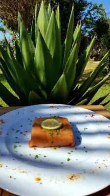 a piece of fish on a plate with a lime on it at L'échappée belle Benslimane in O Ben Slimane