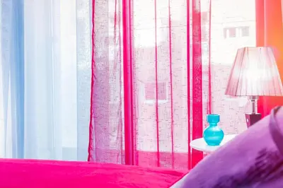 a bedroom with a red bed and a blue vase on a table at Casablanca Home Stay Apartment in Casablanca