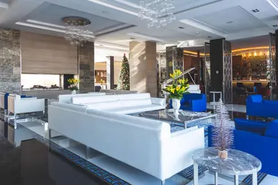 a lobby with white couches and blue chairs at The View Bouznika in Bouznika
