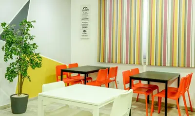 a waiting room with two tables and orange chairs at Manzil Hotel in Casablanca
