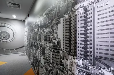 a wall covered in black and white photographs of a building at Manzil Hotel in Casablanca