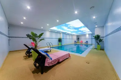 a room with a swimming pool with a table and a chair at Golden Star Casablanca in Casablanca