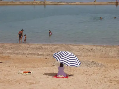 a person sitting under an umbrella on a beach at Appartement Palm Beach in Mohammedia