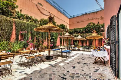 a patio with tables and chairs and umbrellas at LHOSTEL à Casablanca in Casablanca