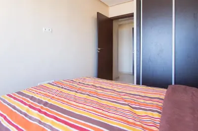 a bedroom with a bed with a colorful striped blanket at Res Mario 3 Lovely Apartment With Balcony & Sea View Free Wifi in Casablanca
