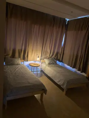 a bedroom with two beds and a table with a lamp at Résidence Evasion in Bouznika