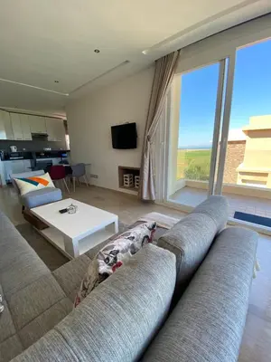 a living room with two couches and a large window at Résidence Evasion in Bouznika