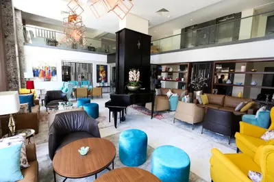a lobby with couches and chairs and tables at Hôtel du Golf Mohammedia in Mohammedia