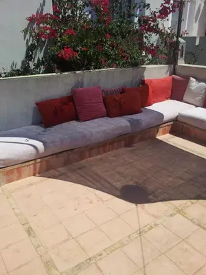 a couch with pillows sitting on a patio at Dar Al Manar in El Jadida