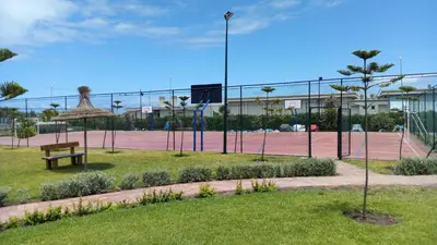 a tennis court with a bench on a tennis court at Savannah Beach D11 in Sidi Rahal
