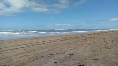 a beach with footprints in the sand and the ocean at Savannah Beach D11 in Sidi Rahal
