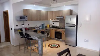 a kitchen with a stainless steel refrigerator and a counter at Savannah Beach D11 in Sidi Rahal