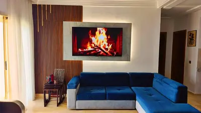 a blue couch in a living room with a fireplace at Savannah Beach D11 in Sidi Rahal
