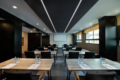 a conference room with tables and chairs and a whiteboard at ODYSSEE Boutique Hotel Casablanca in Casablanca