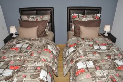 a bedroom with two beds with a comforter and pillows at Elegant Apartment with Balcony in Val Fleuri, Maarif Casablanca, Perfect for Family & Corporate Stays in Casablanca