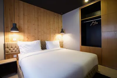 a bedroom with a large white bed and a television at Suite Loc Suite & Spa in Casablanca