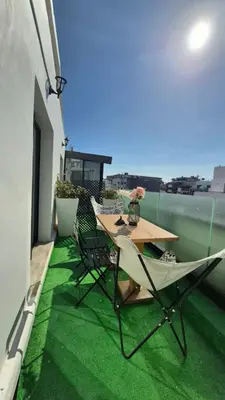 a table and chairs on a balcony with green grass at Suite Loc Suite & Spa in Casablanca
