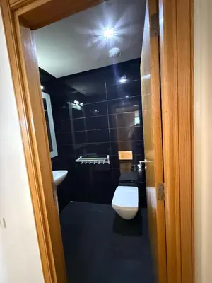 a black bathroom with a toilet and a sink at Appartement Casa-marina au 10ème étage in Casablanca