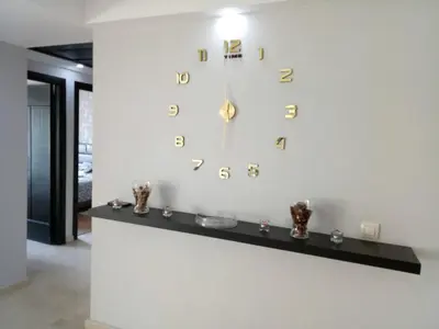 a large clock on a white wall with vases at Apartment with Terrace in Casablanca