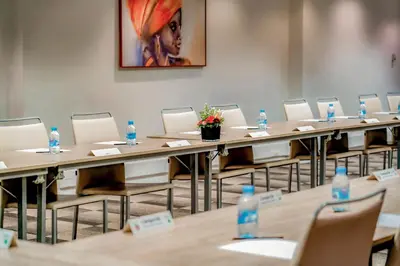 a row of tables and chairs in a room with water bottles at Kyriad Residence Casablanca in Casablanca