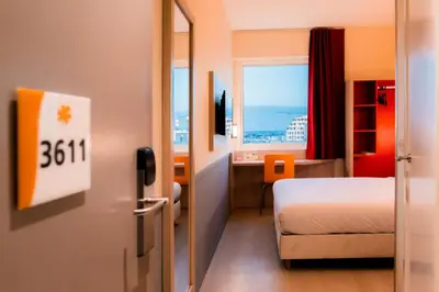 a room with a bedroom with a bed and a window at Premiere Classe Casablanca Centre Ville in Casablanca