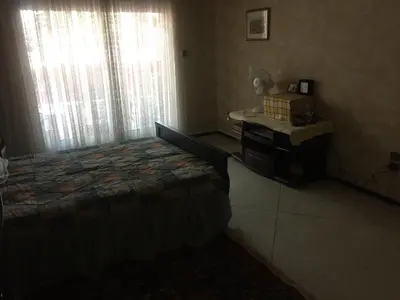 a bedroom with a bed and a desk and window at Property in a quiet area close to the train station and town in Casablanca