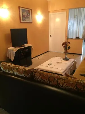 a living room with a table with a tv on it at Property in a quiet area close to the train station and town in Casablanca