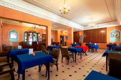 a dining room with blue tables and chairs at Hotel Bellerive in Casablanca