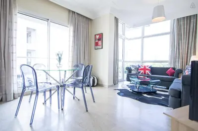 a living room with a glass table and chairs at Luxueux Appart Au Triangle D'Or Casablanca in Casablanca