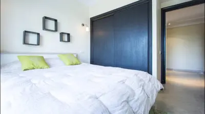 a bedroom with a large white bed with a black wall at Luxueux Appart Au Triangle D'Or Casablanca in Casablanca
