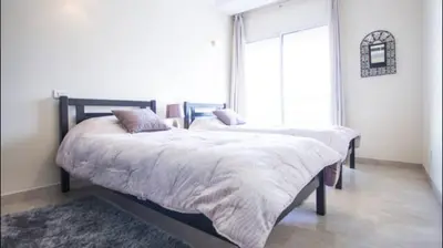 a bedroom with two beds and a large window at Luxueux Appart Au Triangle D'Or Casablanca in Casablanca