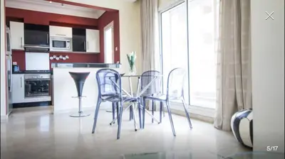 a kitchen with a table and chairs in a room at Luxueux Appart Au Triangle D'Or Casablanca in Casablanca