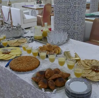 a table with various types of bread and pastries on it at reda land in O Ben Slimane