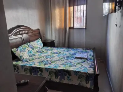 a bedroom with a bed with a floral bedspread at Mohammed V Airport HOME in Deroua