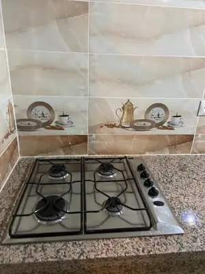 a stove top in a kitchen with plates and a tea kettle at Mohammed V Airport HOME in Deroua