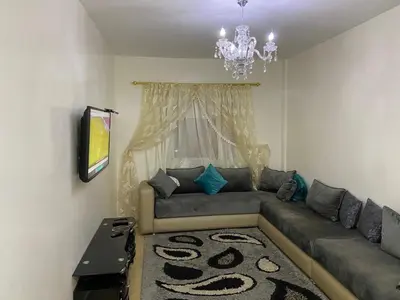 a living room with a couch and a chandelier at Mohammed V Airport HOME in Deroua