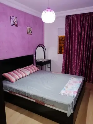 a bedroom with a bed with a purple wall at Mohammed V Airport HOME in Deroua