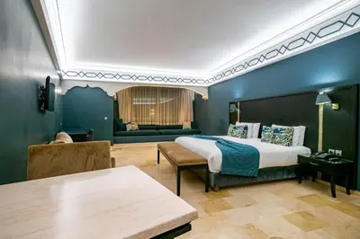 a bedroom with a bed and a couch and a table at Diwan Casablanca Hotel & Spa in Casablanca