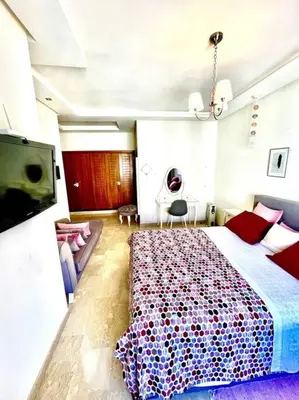 a bedroom with a large bed and a tv at Taj nouaceur aéroport Mohamed V in Nouaseur